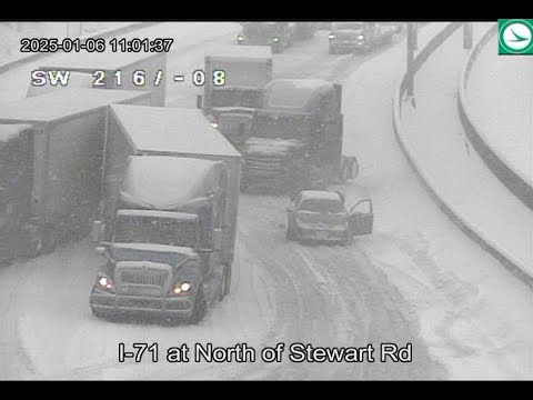 Cars, trucks struggle to get up snowy highway hill