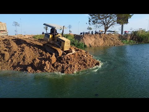 Updated processed 15% road construction across lake to connect point by D31 dozer with dump truck