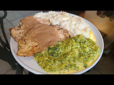 Seasoned oven-roasted chicken breasts with chicken gravy mashed potatoes and broccoli and cheese