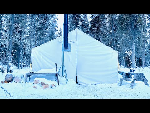 Winter camping overnight in a canvas tent with a wood stove